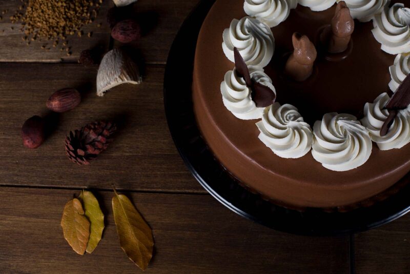 Pastel conejo de Lecaroz, decorado con ganache de chocolate, conejos de chocolate y crema blanca