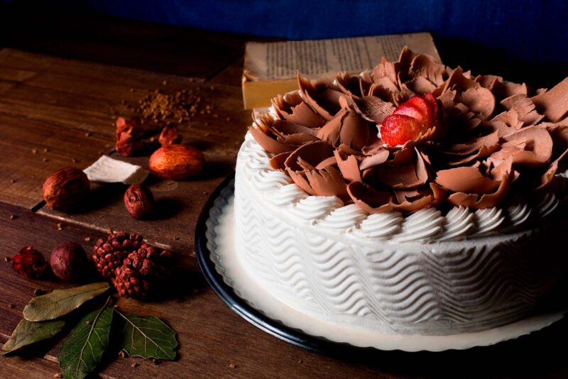 Pastel conquista de fresa de Lecaroz, decorado con hojuelas de chocolate de leche y fresas