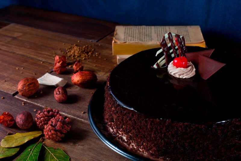 Pastel chocoqueso de Lecaroz, decorado con ganache oscuro, reja de chocolate bicolor y cereza