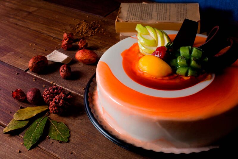 Pastel Dalí de Lecaroz, decorado con ganache de dos colores y fruta mixta