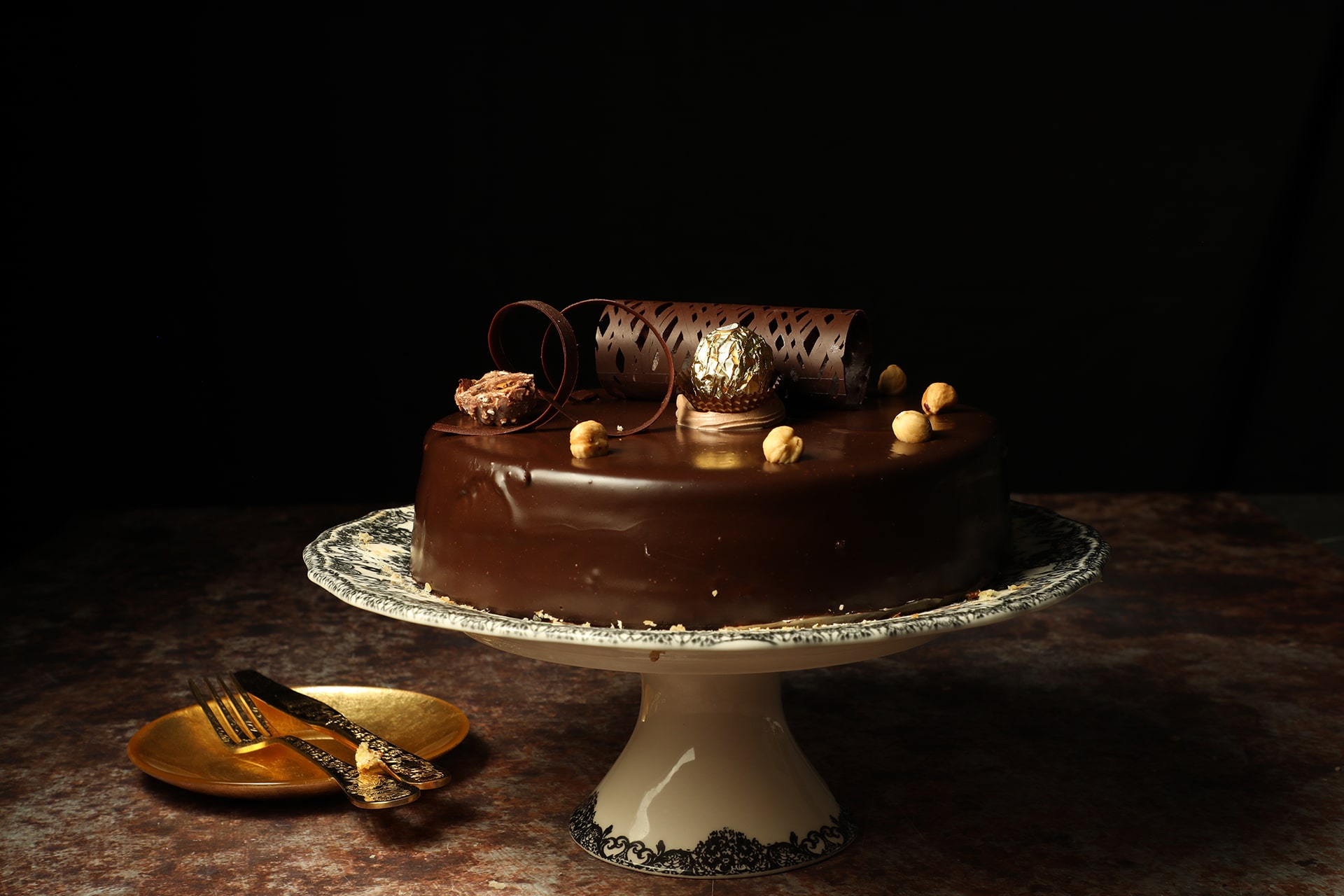 Pastel ferrero de Lecaroz, decorado con ganache oscuro, avellanas, chocolate ferrero y espirales de chocolate